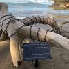 A small solar panel with PW/WW fairy lights on the beach