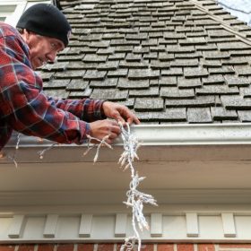 A man decorating fringes fairy lights at home